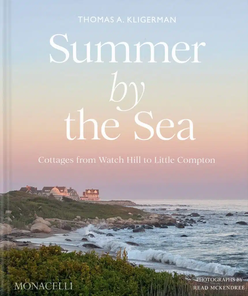 Book cover: seaside cottages, rocky shore, grass, and pastel sky at sunset, text “Summer by the Sea.”.
