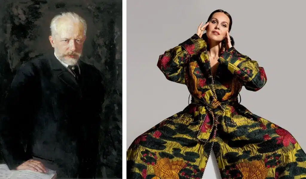 A stern man in a suit is beside a woman posing in a vibrant, floral wide-legged outfit.