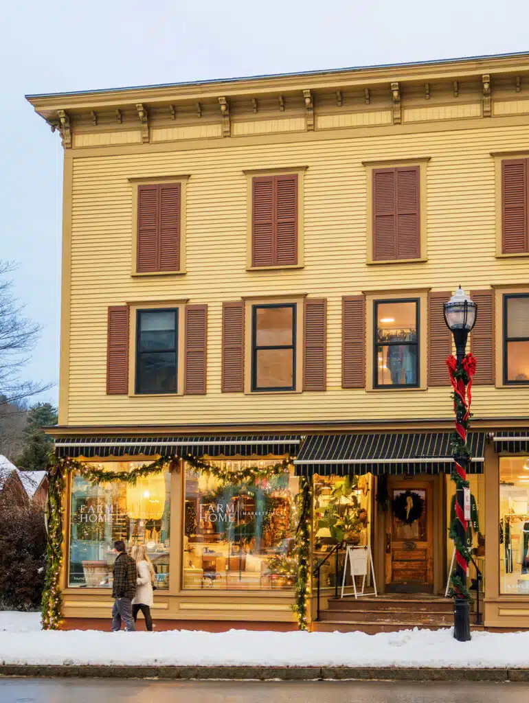 Christmas in Stowe, Vermont | A Magical Holiday Getaway. Yellow building with a Farm Home marketplace storefront decorated for the holidays.