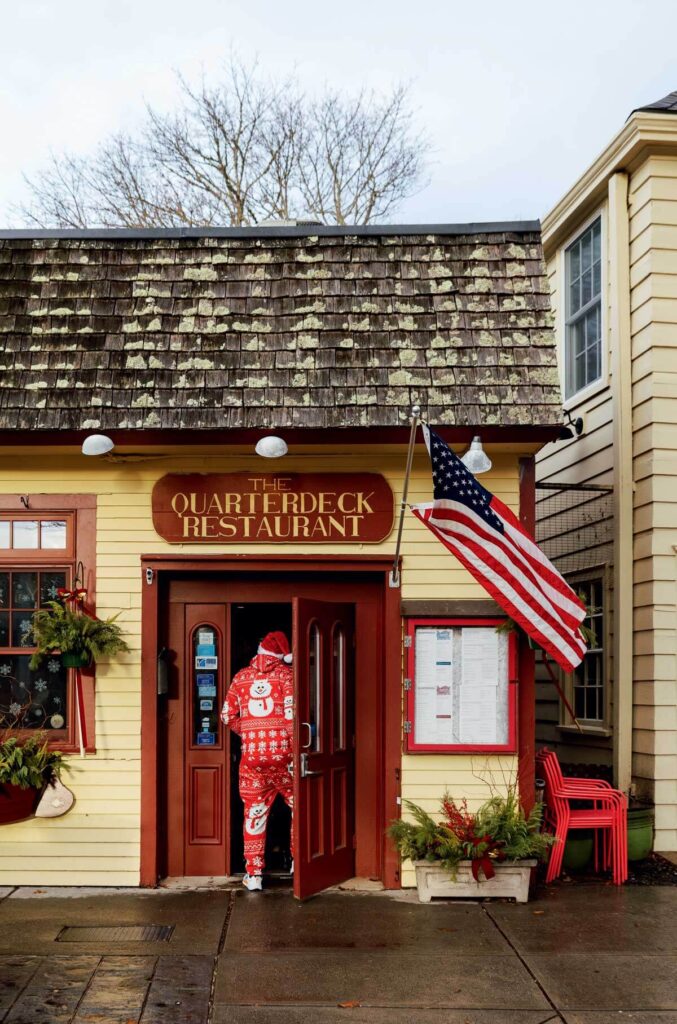 A person wearing red and white snowman pajamas entering The Quarterdeck Restaurant.
