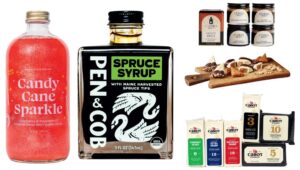 A collection of food products including Candy Cane Sparkle cocktail mixer, spruce syrup, spice jars, and cheddar cheese.