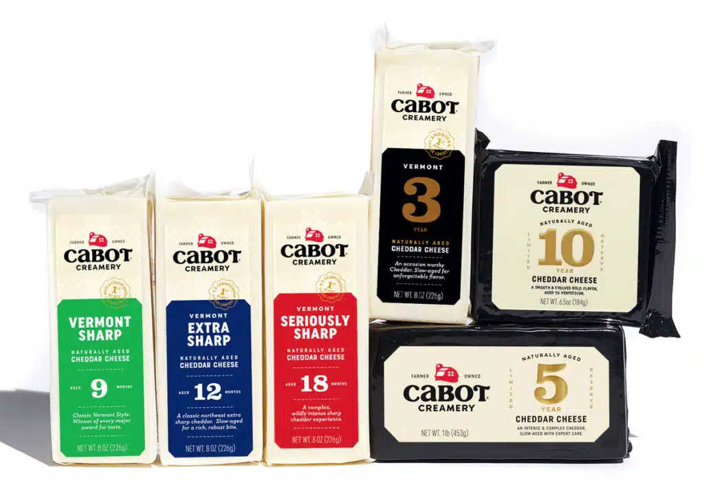 An assortment of Cabot Creamery cheddar cheese blocks in various ages and packaging colors.
