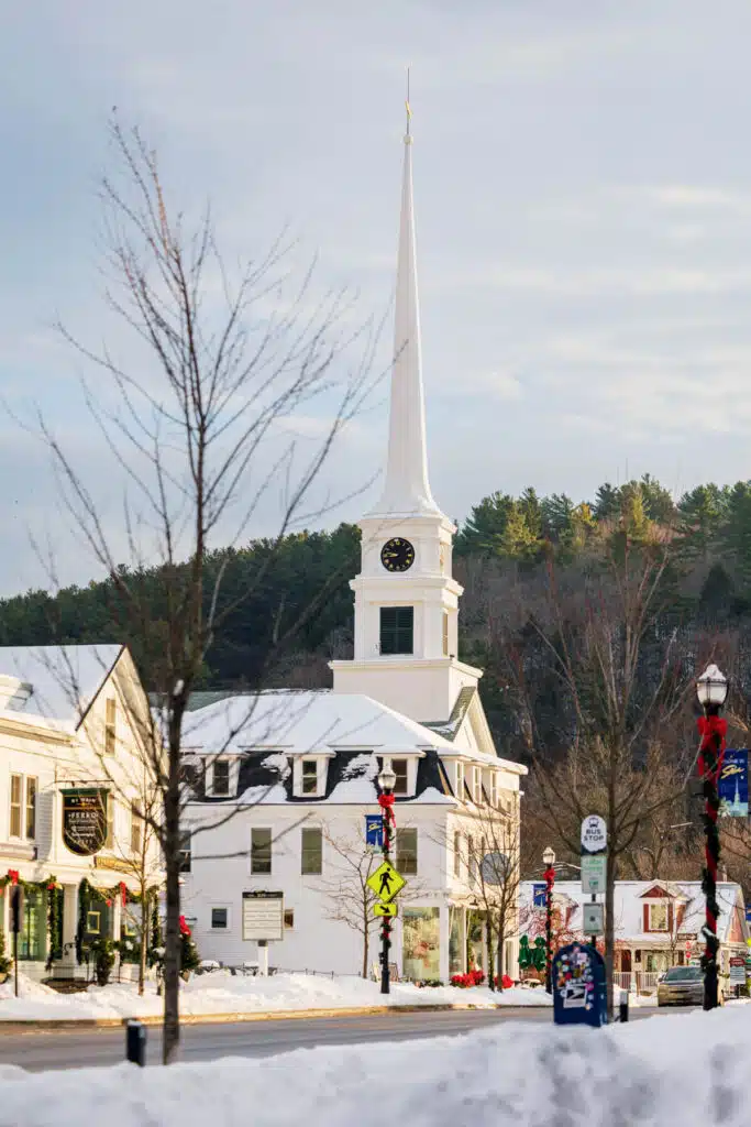 Christmas in Stowe, Vermont | A Magical Holiday Getaway. A white church with a tall steeple in a snowy town center.