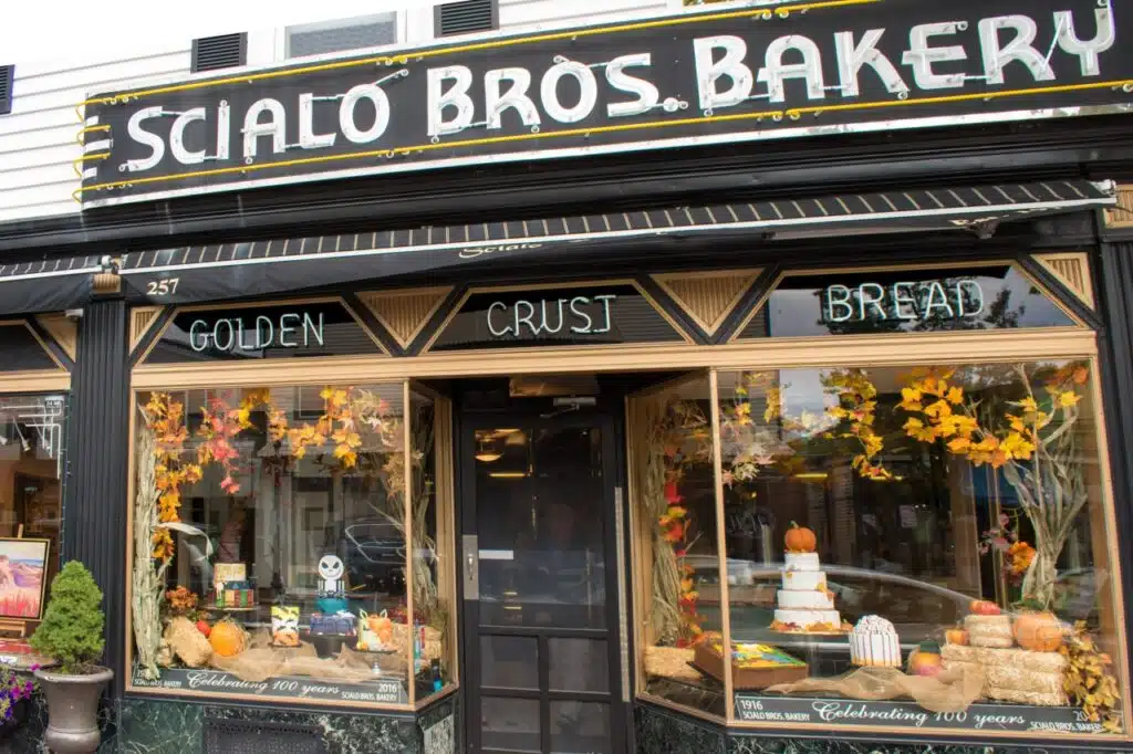 Storefront of Scialo Bros. Bakery decorated with autumn leaves, pumpkins, and cakes in the window displays.