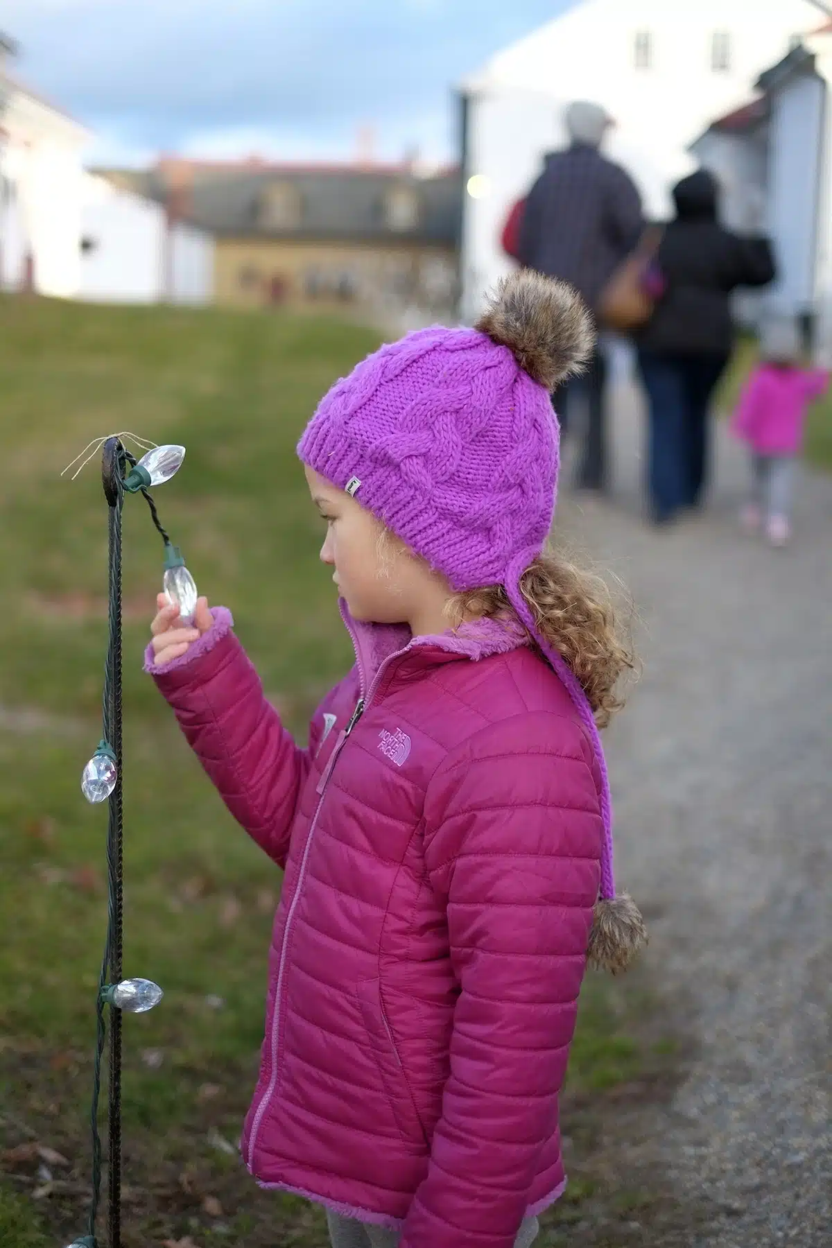 Lucy examines an unlit light, one of many strung throughout the village to light the pathways in the evening.