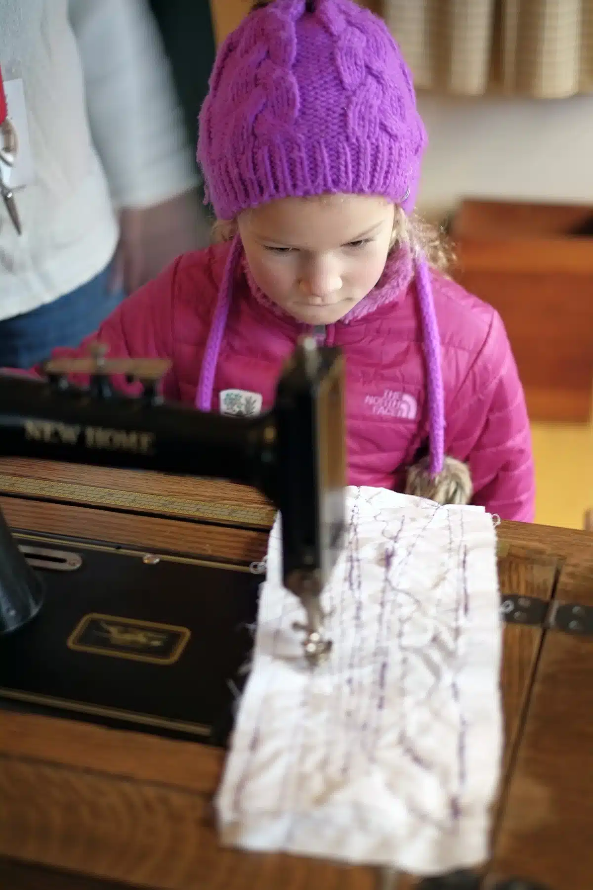 Practicing stitches on a vintage sewing machine in the Sisters' Shop.