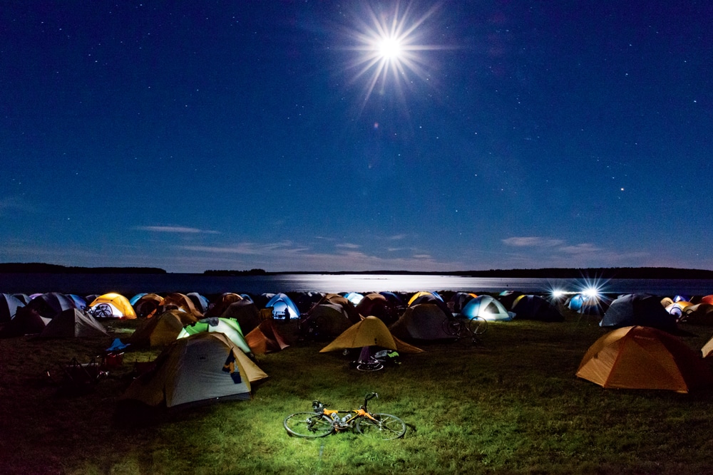 As a brilliant moon rises overhead, cyclists bed down on Kelley Point in Jonesport.