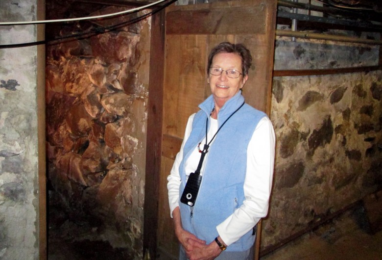 Jody Newman in full tour-guide mode, standing at the cellar nook that may have been a stop on the Underground Railroad.