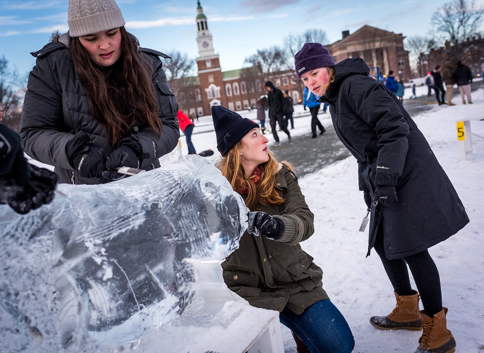 Dartmouth College Winter Carnival Ice Sculpture Contest. Katherine Flessel of Hillsborough, CA., Hayley Nichols of Ketchikan, AK. & Alison Clarke of Westchester, NY work on their entry.