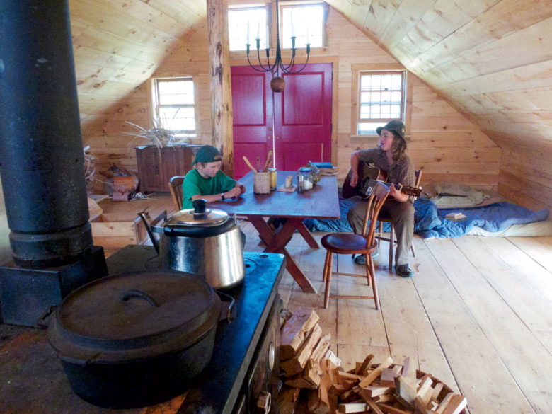 The Hewitts are  living  in a single room above the barn until their house is built, but with a woodstove and a row of mattresses, Ben says it’s “cozy enough.”