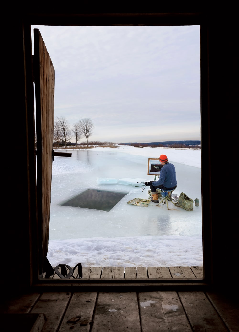 Painter Eric Aho at work, framed by the doorway of his hand-built sauna in Walpole, New Hampshire.