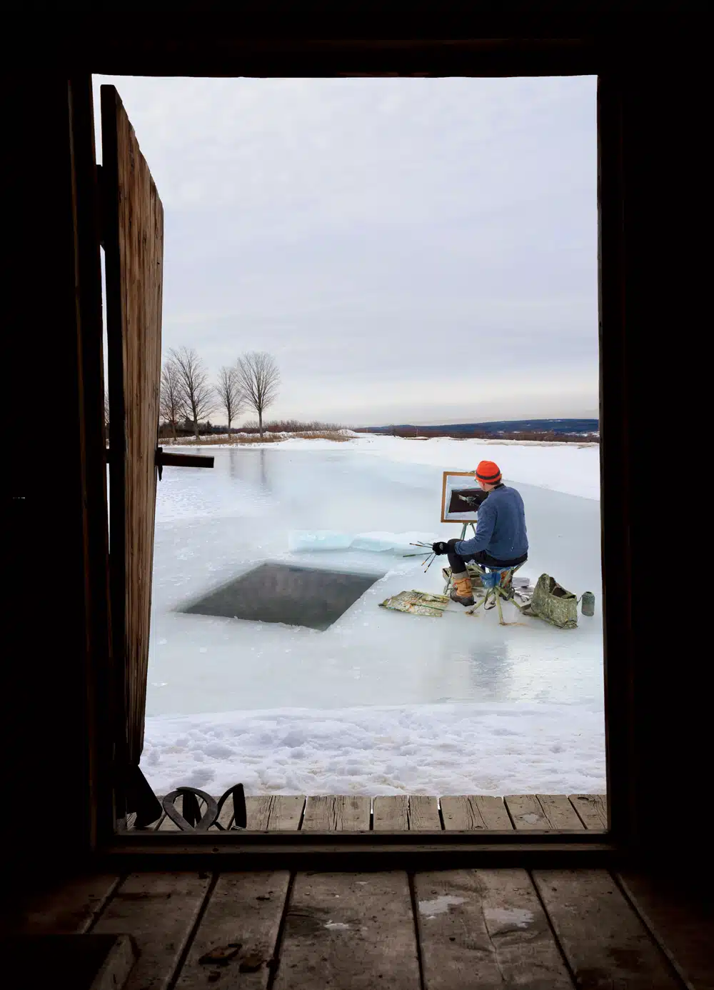 Painter Eric Aho at work, framed by the doorway of his hand-built sauna in Walpole, New Hampshire.
