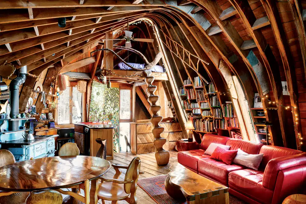 Ceiling and wall supports double as design elements in the second-floor living and dining space, from which floating stairs lead to a cozy sleeping loft.