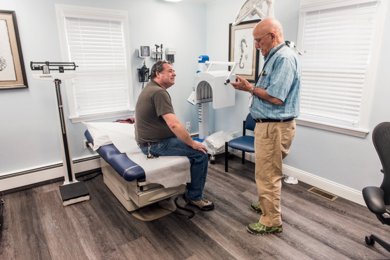 Lepore chats with patient Kenneth Bidlack during a checkup. The room’s institutional decor isn’t Lepore’s style, but his own office was being renovated at the time.