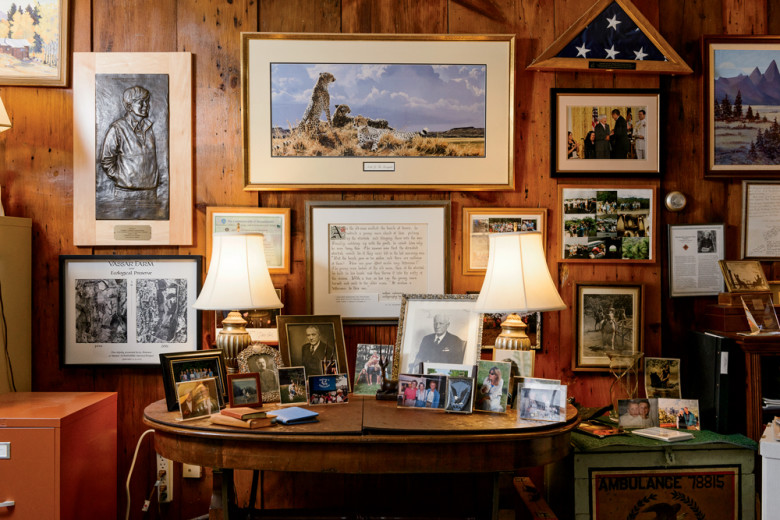 Family photos share space in Liz’s den with awards and reminders of her long career. At left is a relief of Liz created by sculptor Larry Nowlan, an SCA alum. On the table, the large photo left of center shows Liz’s father, Edward Sanderson Cushman, who helped instill in his daughter a love of wild places. 