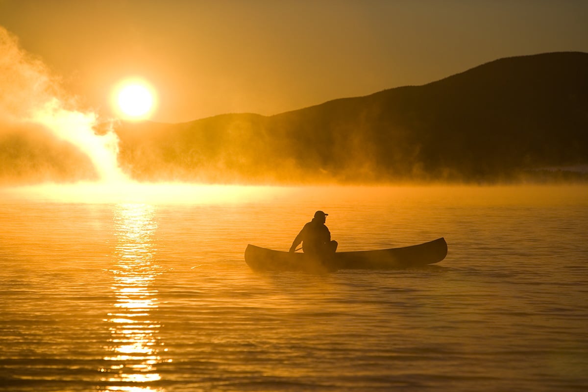 Canoeing in Lily Bay at sunrise, Moosehead Lake, Maine. (MR)