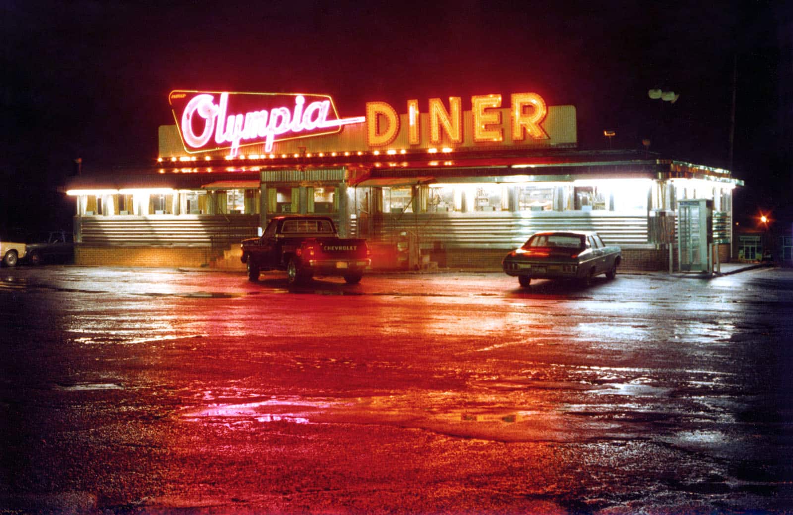 Title: Olympia Diner, November 27, 1981 Location: Newington, CT. Judge's comments: "When we think of New England, we often think of colorful fall days. New England can be industrial and urban, as well as rural and scenic. New England includes six states that have varied cultures and landscapes. That is why I am drawn to this night photograph bathed in red-light reflections. This often-photographed landmark diner in Connecticut originally opened in Massachusetts and was moved to its present location in 1954. It is made of stainless steel and is the longest of its kind in the United States. It is a cross-country highway pit stop as well as a popular dining post for locals and those “in the know.”" 