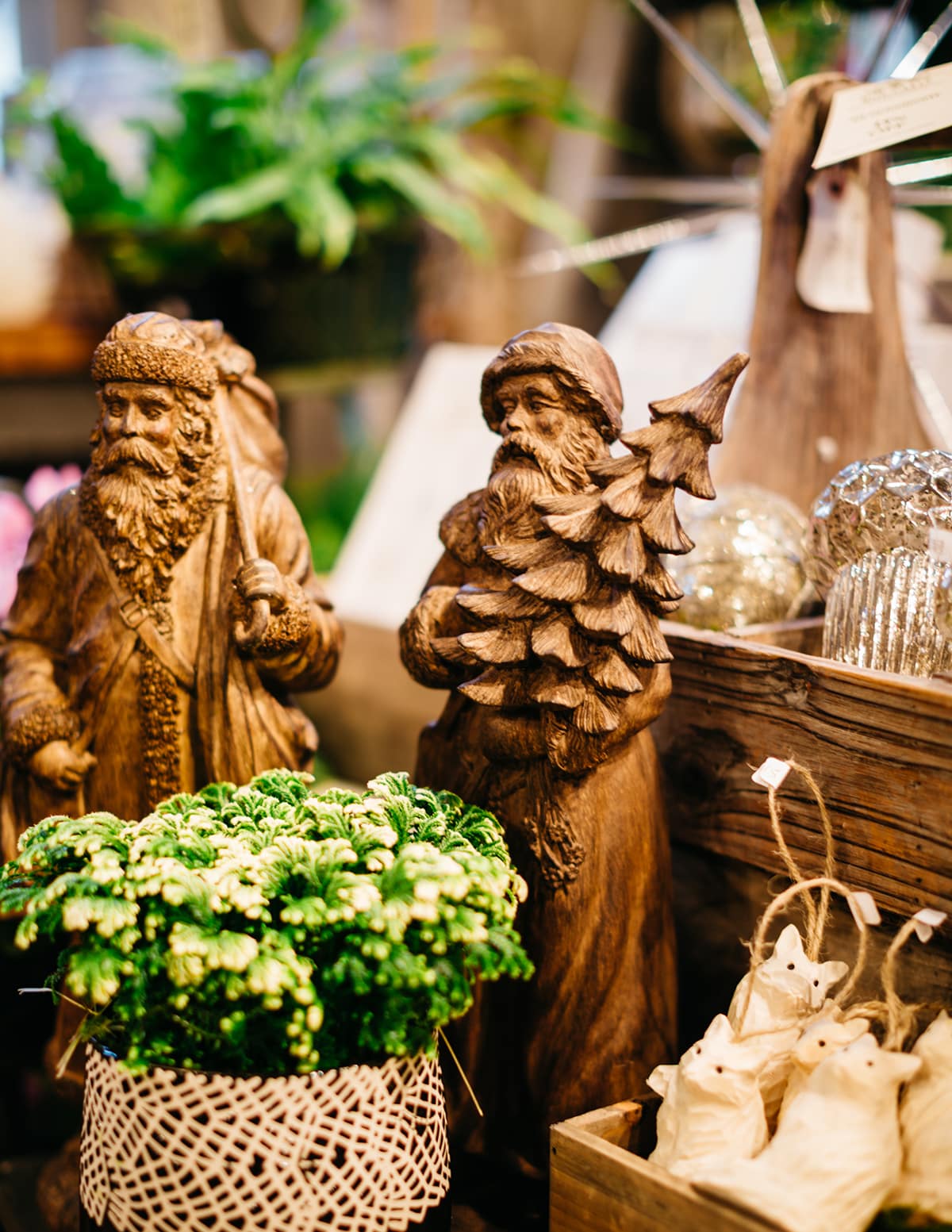 Wooden Ornaments and Santas surrounded by holiday greens at Rouvalis Flowers on Beacon Hill.
