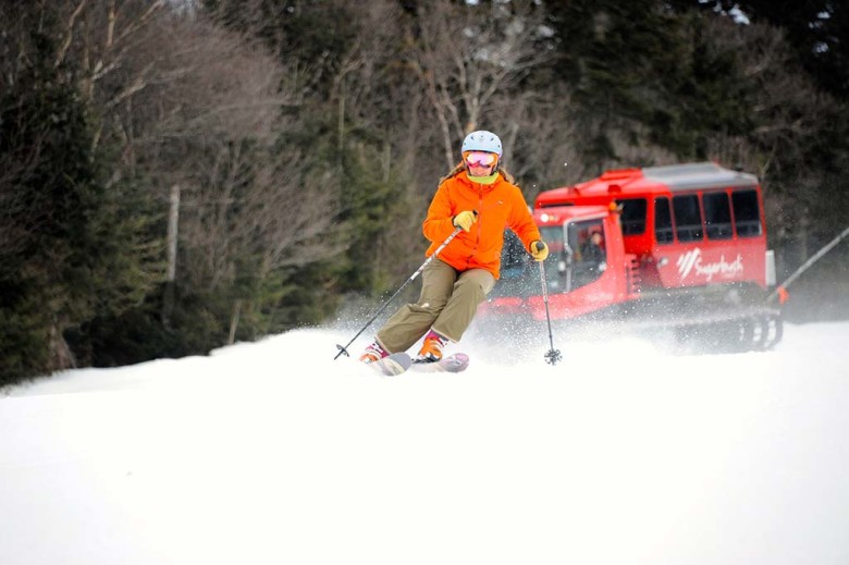 A skier tackles some fresh snow at Sugarbush with the Lincoln Limo following behind. 