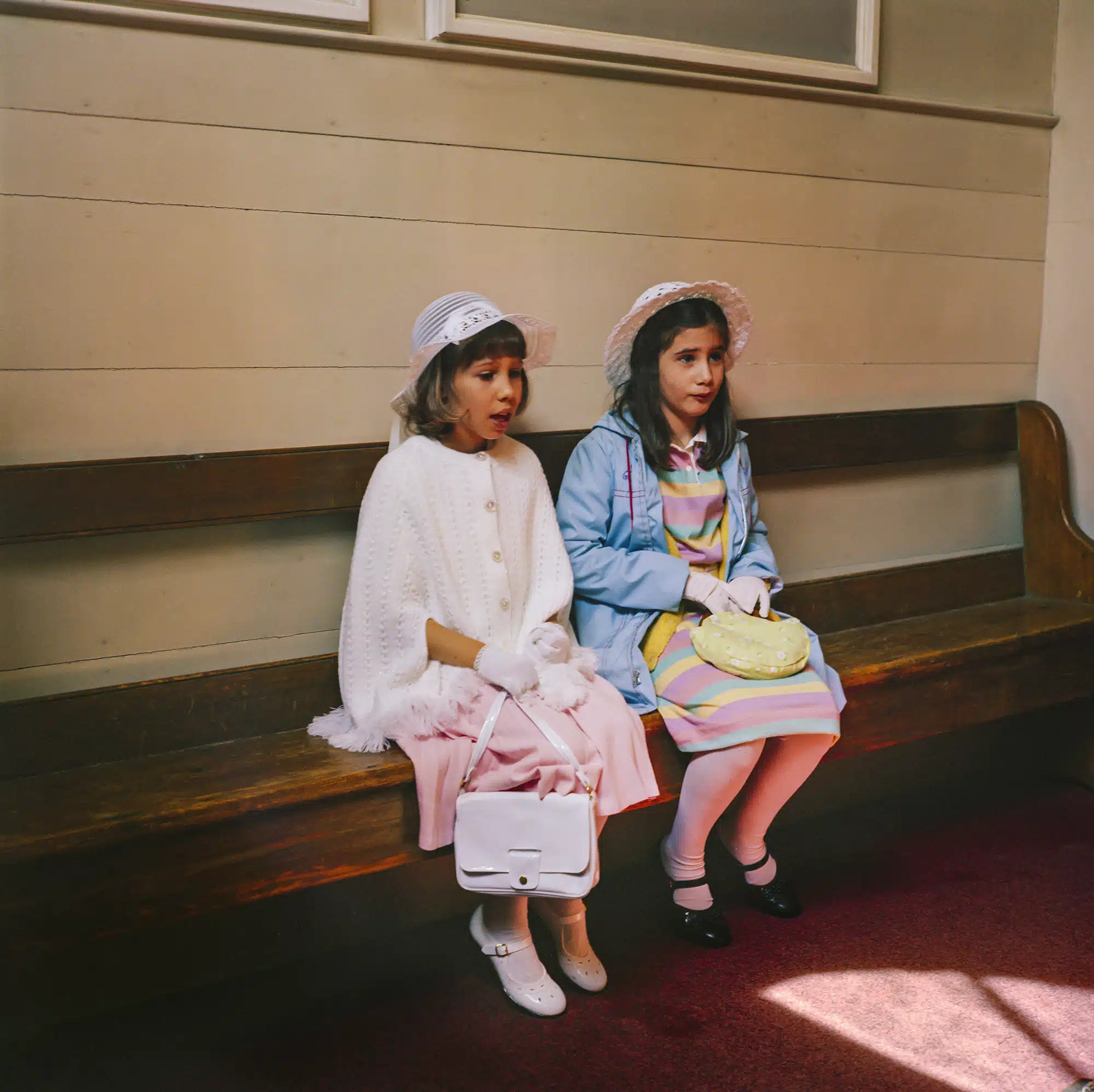 Sunday School - 1982 "My plan was to take a photograph of a lovely and very beloved woman who had polio and every Sunday she would brave the steps, bent over almost in half, and climb up the steps. She did this with grace and always with a big smile on her face. She is just one of those special people. I did get a few shots of her but I didn’t think they came out very good. These two girls were sitting on the wooden bench exactly where I had sat hundreds of times in my patent leathers, ankle sox and Sunday best."