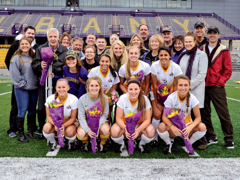 “It gave me chills,” Todd wrote of seeing his two soccer-star children win improbable game after game. Here the Albany Lady Danes celebrate their 1-0 win against Maine that clinched them a spot in the post-season conference tournament. Daughter Celia (#2) is in second row in front of her parents Patty and Todd.