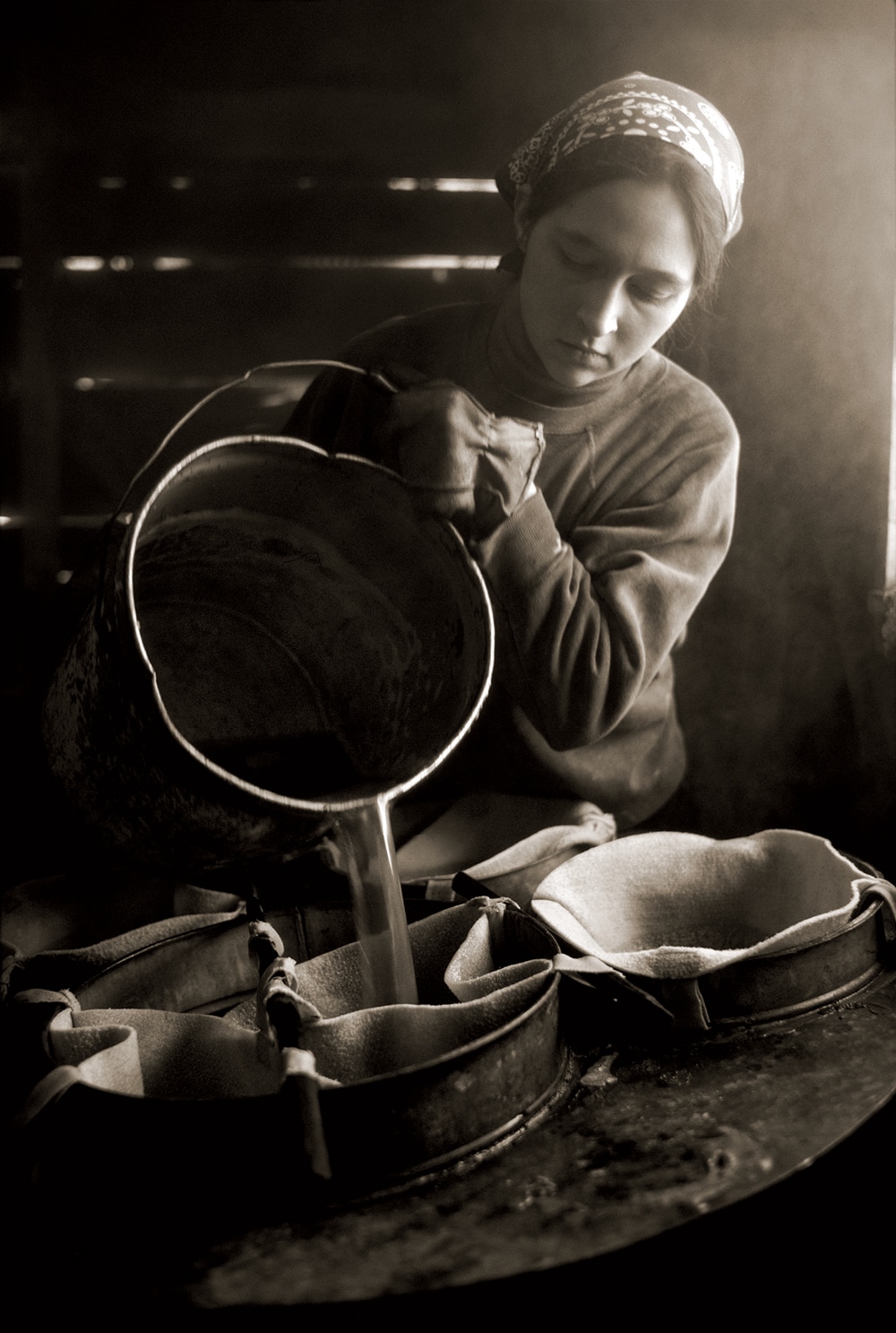 Filtering Syrup, Barnet, 1977. When Brown saw Katherine Roy filtering maple syrup at her farm, “all I could think of was Vermeer and his paintings, because of the light,” he says. “It was so beautiful.” 