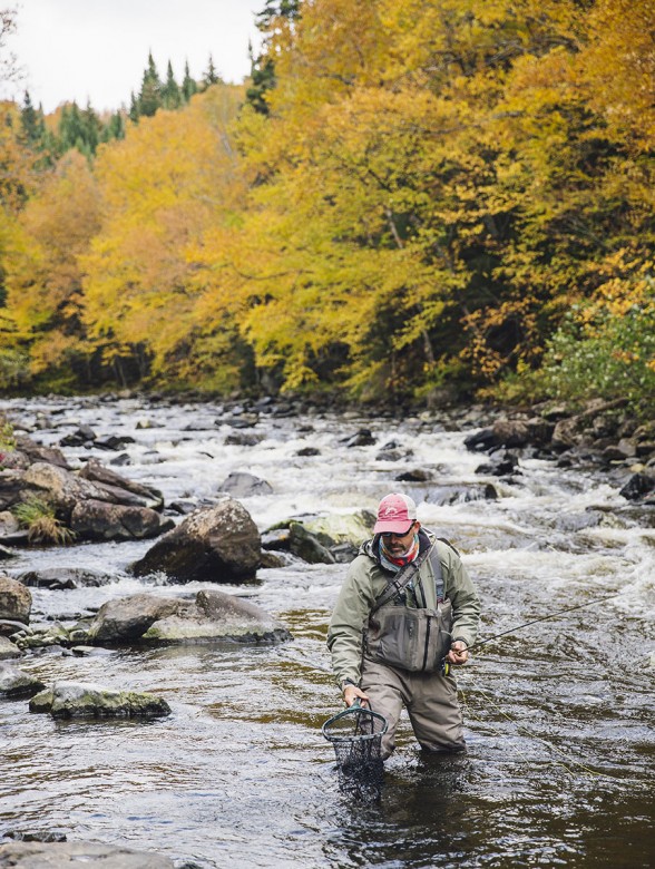 Bill Bernhardt, head fishing guide for the Cabins at Lopstick in Pittsburg, New Hampshire, brings in a small brook trout.