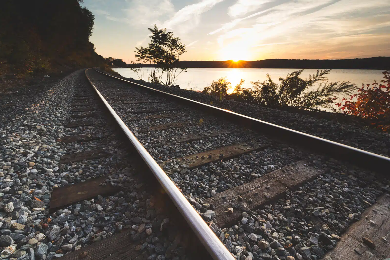 Title: Golden Rails Location: Gales Ferry, CT Judge's comments: "This photo depicts the back roads of the Connecticut shoreline. If you’re a train traveler you may know the route, but not many have viewed the scene from land. Only the locals know this secret. Through the eyes of the artist, it is as if we are there walking the tracks with him. Each wooden railroad tie is a breath and a step forward. As we look ahead to the vanishing point on the horizon, the tracks bear right along the shore and approach the setting sun. The sun is the protagonist in this narrative, but the tools the artist uses to draw our gaze towards the end of day are as important as the sun itself."