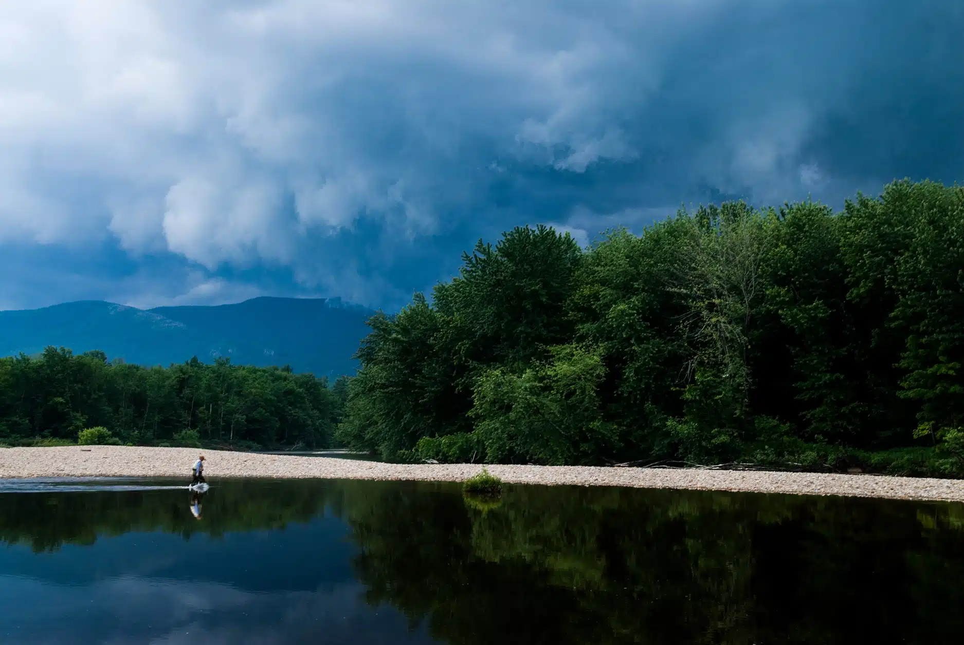 Lone fisherman on the Saco River near North Conway during a spring storm.