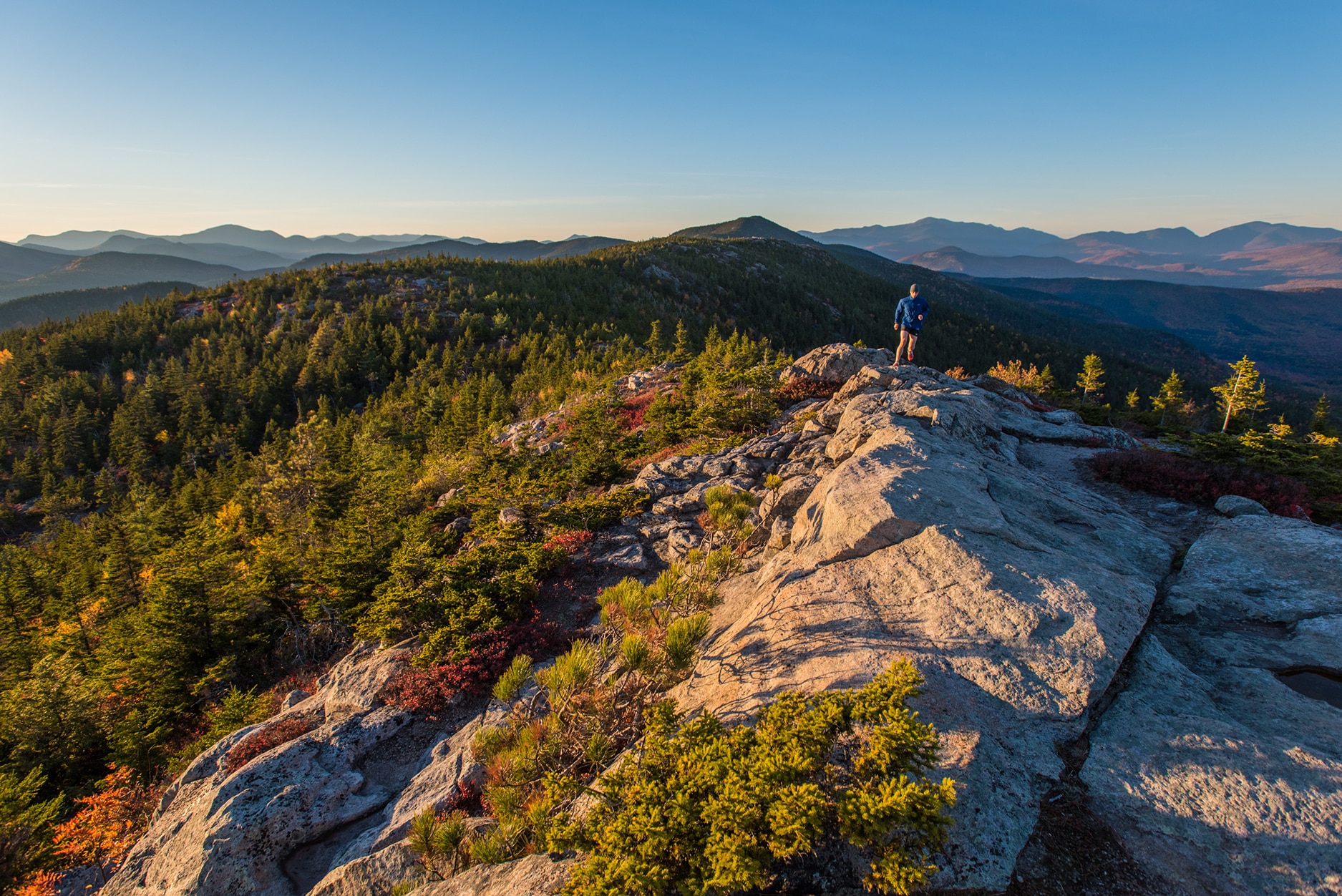 Trail runner high above North Conway, New Hampshire on South Moat Mountain.
