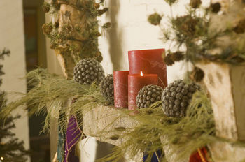 Combine pine cones, evergreen boughs and candles on a mantelpiece for a rustic take on Christmas decor.