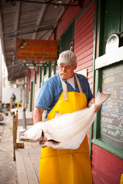 "Buzzy" Dow (with a halibut) is a former fishing boat captain. Now he gives his expertise to customers at Portland's Harbor Fish Market. 