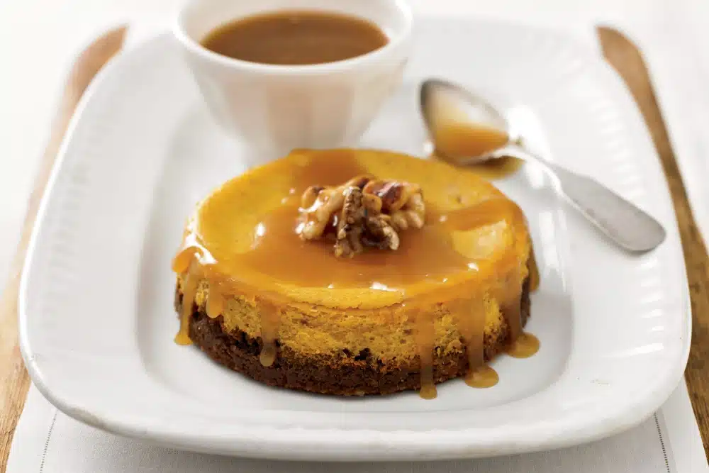 Pumpkin Cheesecake with Walnut-Ginger Crust and Caramel Sauce