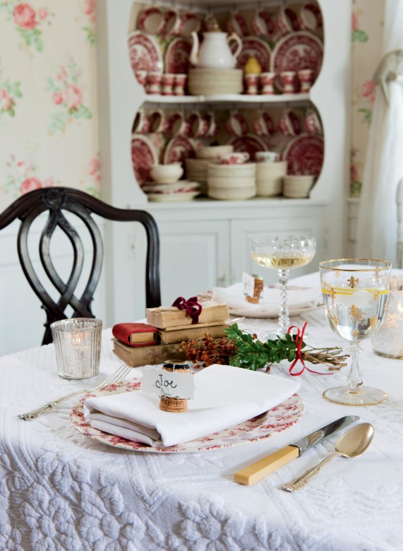 In the dining room, sparkly decorations, antique English china, and vintage linen napkins reflect the joy of the holiday.