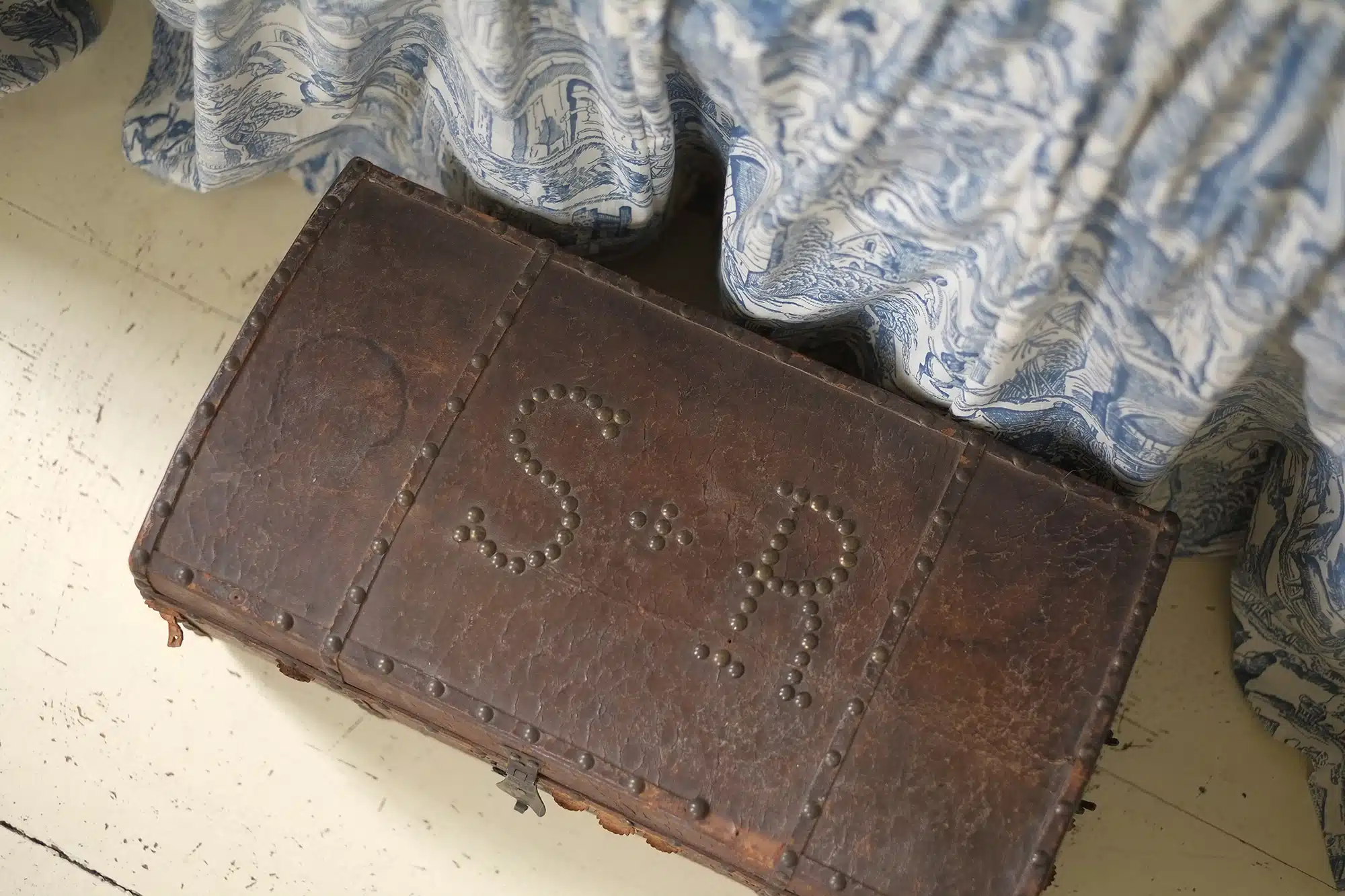 Bedside leather trunk with nail head details in one of the upstairs bedrooms at Wells-Thorn House.