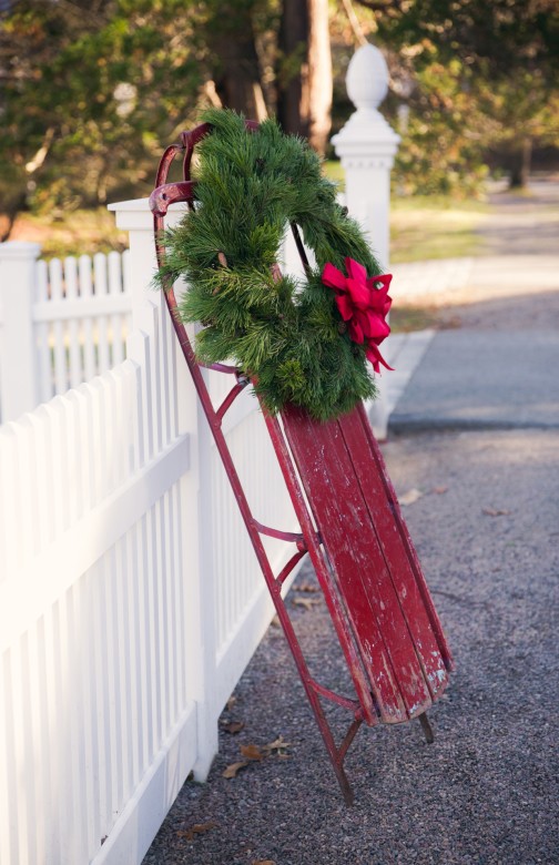 Is there a more classic Christmas decor combination than the cheerful red sled and white picket fence? 
