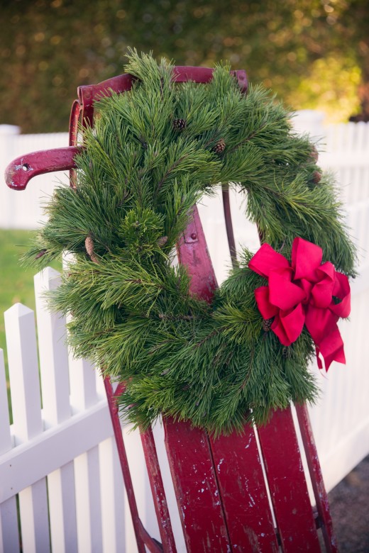 A classic wreath and red ribbon to dress up this vintage family sled for the holidays. 